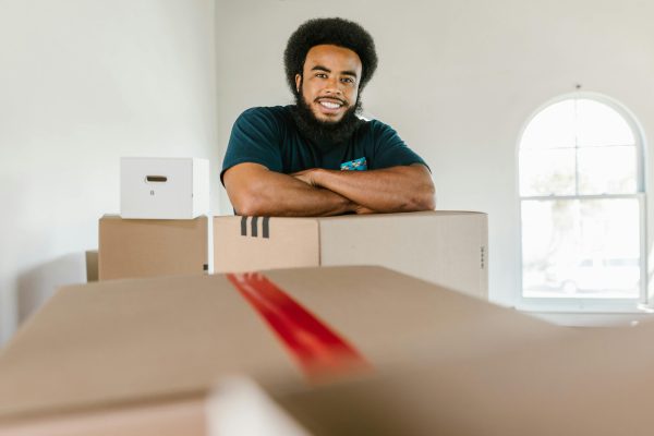 Man smiling over moving boxes - Visit rsd-storage.com.